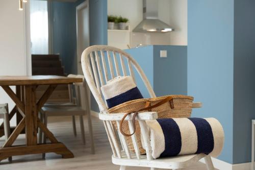 a wicker chair with towels on it in a room at Cliper Apartments by Escampa Hotels in Platja  d'Aro