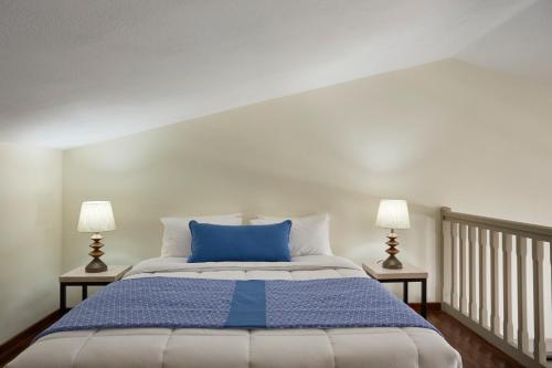 ein Schlafzimmer mit einem blauen Bett mit zwei Lampen in der Unterkunft Skiathos Living in Skiathos-Stadt