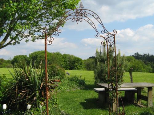 a bench sitting in the grass next to a field at Le Coq Nientiedt in Rösrath