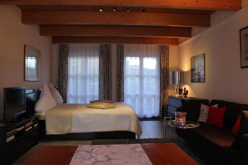 1 dormitorio con 1 cama y sala de estar en Le Coq en Rösrath