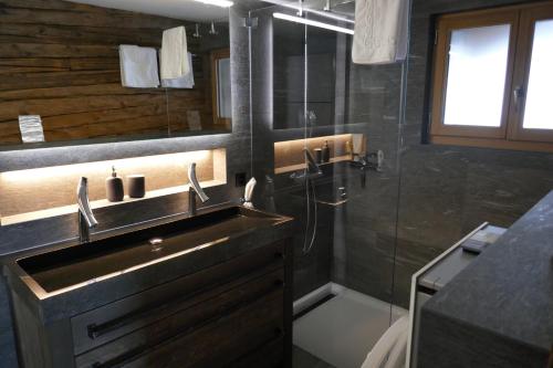 a bathroom with a sink and a shower at Châlet Birkhahn in Saas-Fee