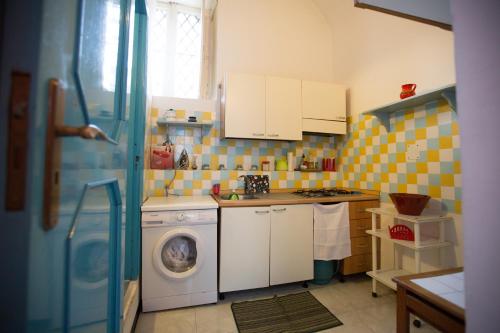 a kitchen with a washing machine and a washer at Appartamento al Teatro Massimo in Catania