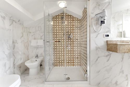 a bathroom with a shower, toilet and sink at Hotel Casanova in Venice