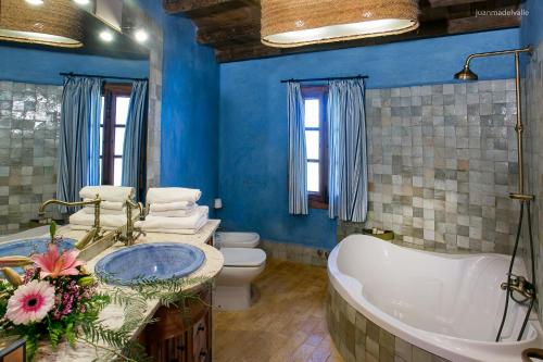 La salle de bains bleue est pourvue d'une baignoire et de toilettes. dans l'établissement Ardea Purpurea, à Villamanrique de la Condesa