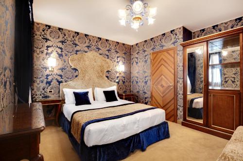 a bedroom with a bed with blue wallpaper at Hotel Casanova in Venice