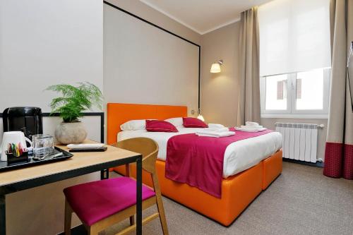 um quarto de hotel com uma cama e uma secretária em Colonna 32 em Roma