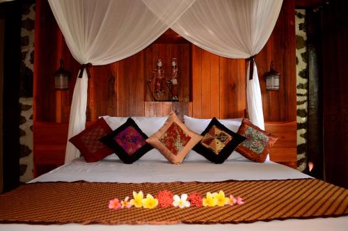 una camera da letto con un letto con cuscini sopra di Tangkoko Sanctuary Villa a Bitung