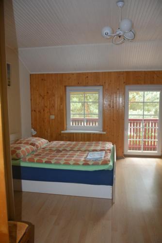 a bedroom with a bed and two windows at Guesthouse "Nakvynė pas žveją" Vetrungiu Street 298-2 in Nida