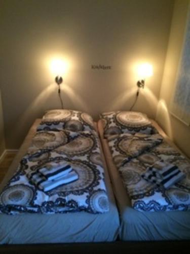 two beds in a small room with lights on the wall at Ferienwohnung Eckloff in Lutherstadt Wittenberg