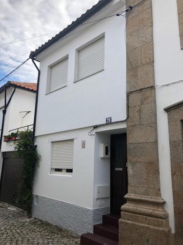 a white house with a black door at Casa da Joana! in Murça
