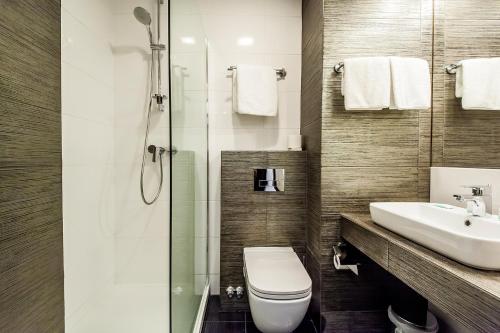 a bathroom with a toilet and a sink and a shower at Hotel 500 in Zegrze