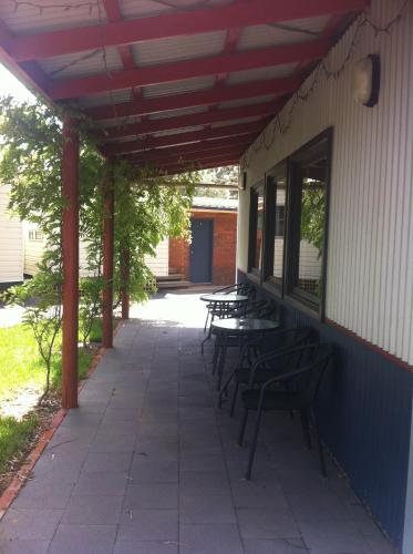 a patio with tables and benches on the side of a building at Golden Country Motel and Caravan Park in Maryborough