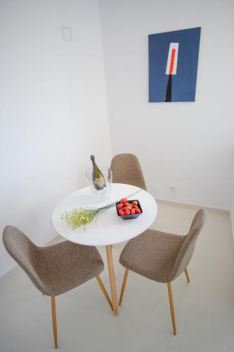 a white table with two chairs and a bowl of fruit at Apartamentos Pinhão in Lagos
