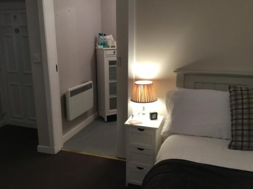 a bedroom with a bed and a lamp on a night stand at Ingleneuk Bed and Breakfast in Edinburgh