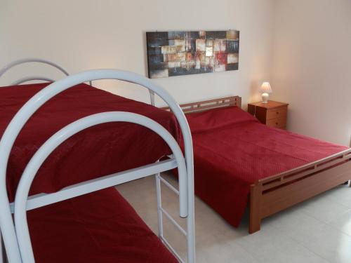 夏卡的住宿－Appartamento Mare，一间卧室配有一张红色床罩的床