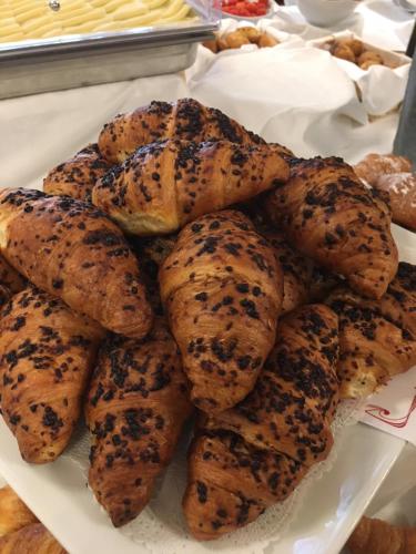 a pile of bagels sitting on top of a plate at Palace Grand Hotel Varese in Varese