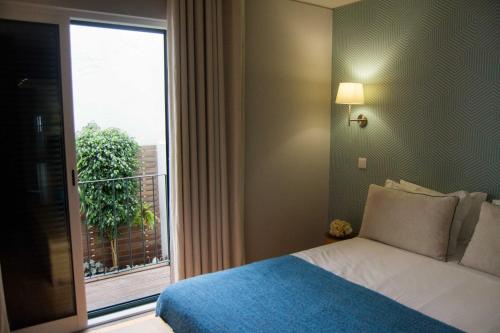 a bedroom with a bed and a large window at Apartamentos Santa Maria by Heart of Funchal in Funchal