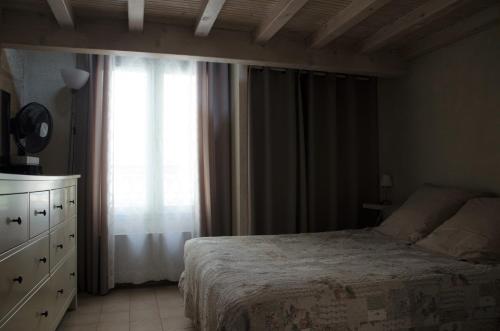 une chambre avec un lit, une commode et une fenêtre dans l'établissement la pitchoun des Arènes, à Arles