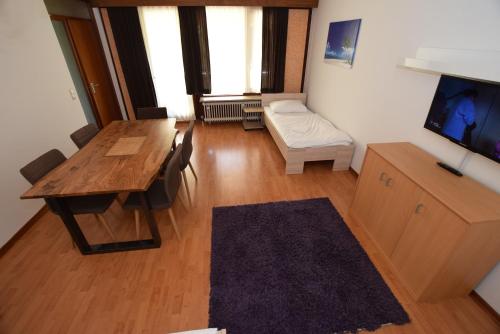 AB Apartment Objekt 39 في شتوتغارت: غرفة معيشة مع طاولة خشبية وأريكة