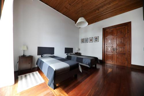 アングラ・ド・エロイーズモにあるAngra Downtown Flatのベッドルーム1室(ベッド2台付)、木製のドアが備わります。