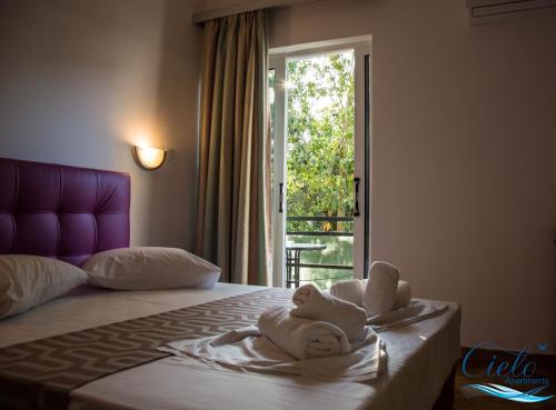 a hotel room with a bed with towels on it at Cielo Apartments in Poros