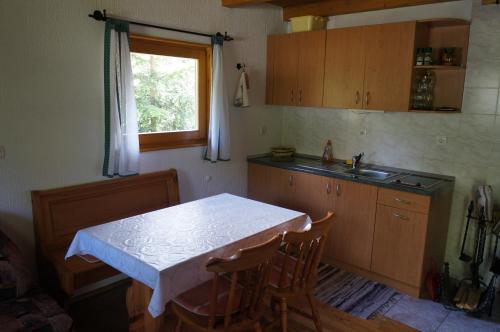 a kitchen with a table and a sink and a window at Na Rebri in Luče