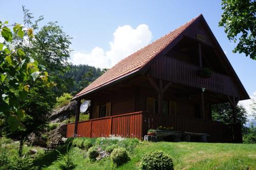 une grande maison en bois avec un toit rouge dans l'établissement Na Rebri, à Luče