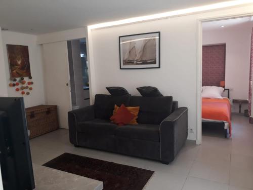 un salon avec un canapé et un lit dans l'établissement Le Tivoli, à Cannes