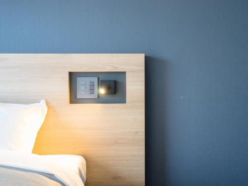 a bedroom with a blue wall with a lightswitch at Resters Bed&Co. in Kumamoto