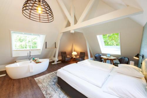 a bedroom with a large bed and a bath tub at B&B Landgoed De Grote Beek in Eindhoven