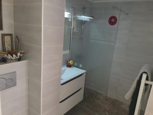 une salle de bain blanche avec une douche et un lavabo dans l'établissement Le Tivoli, à Cannes