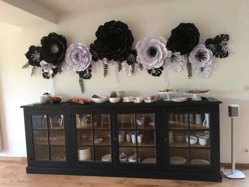 a cabinet with black and pink flowers on the wall at Maison d'hôtes & SPA La Scierie in Salins-les-Bains