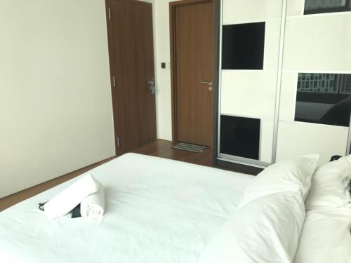 a white bed with a clock on top of it at VORTEX SUITES KLCC by PNUT With NETFLIX in Kuala Lumpur