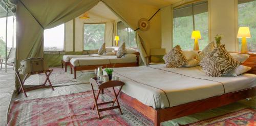 a bedroom with two beds in a tent at Entumoto Toto Camp in Ololaimutiek