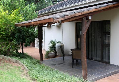 a pergola on the side of a house at Bush Lovers Lodge in Modimolle