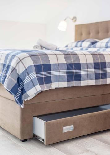 a bed with a wooden frame with a drawers at Apartments The heart of Croatia in Pirovac