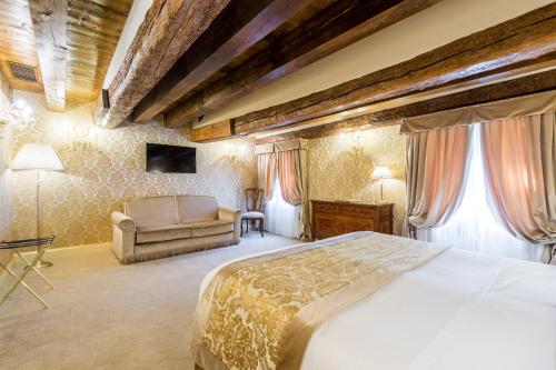 a bedroom with a large bed and a couch at Hotel Ai Cavalieri di Venezia in Venice