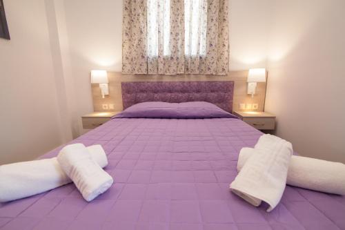 a bedroom with a purple bed with two pillows at Del Mar 'Adults Only' in Stalida