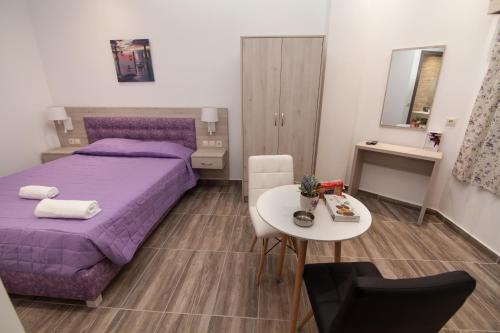 a bedroom with a purple bed and a table at Del Mar 'Adults Only' in Stalida