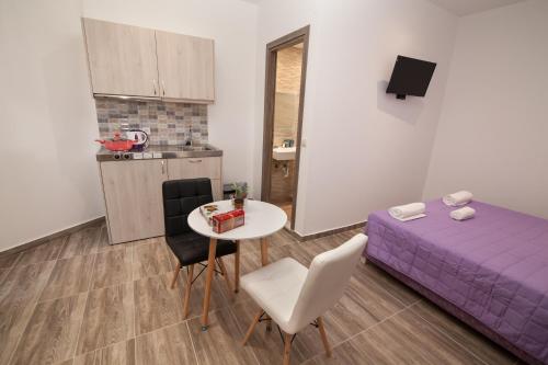 a small room with a purple bed and a table and chairs at Del Mar 'Adults Only' in Stalida