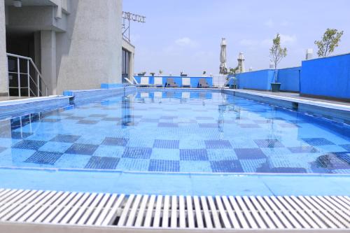 a swimming pool with a blue and white tile floor at Momona Hotel in Addis Ababa