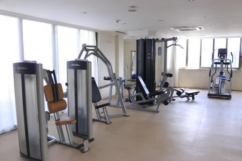 a gym with several treadmills and machines in a room at Momona Hotel in Addis Ababa