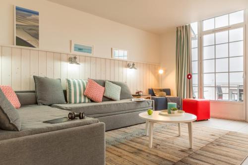 a living room with a couch and a table at Pierre & Vacances Premium Résidence de la Plage in Le Crotoy