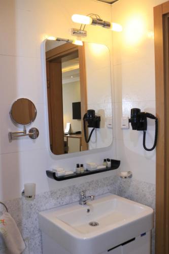 a bathroom with a sink and a mirror at Momona Hotel in Addis Ababa