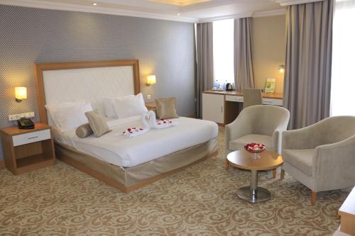 a hotel room with a bed and two chairs at Momona Hotel in Addis Ababa