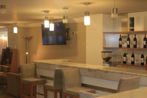 a bar with chairs and a counter with bottles of wine at Momona Hotel in Addis Ababa