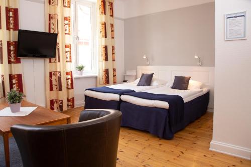 una camera d'albergo con letto, tavolo e sedie di Hotel Emma a Östersund