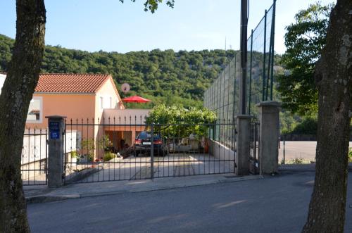 a fence with a car parked in front of a house at Apartments Lilly in Rijeka