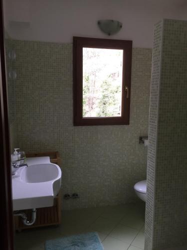 a bathroom with a sink and a window at The River House in Agaggio Inferiore