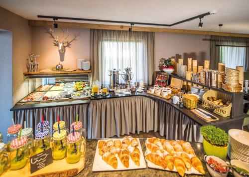 a buffet with bread and other food on a table at Gourmet AlpinHotel Sonnleiten in Cadipietra